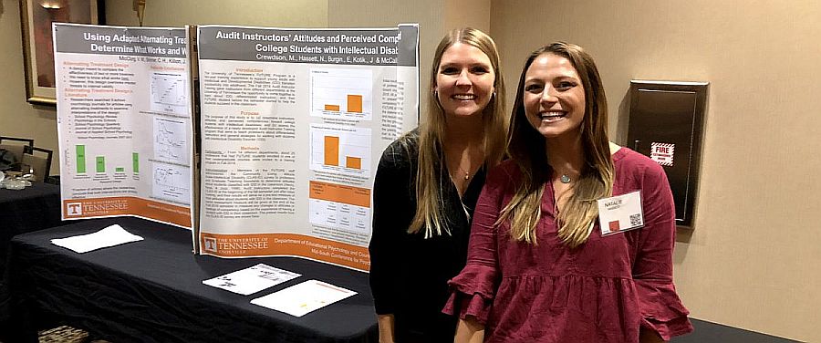 two grad students presenting at conference